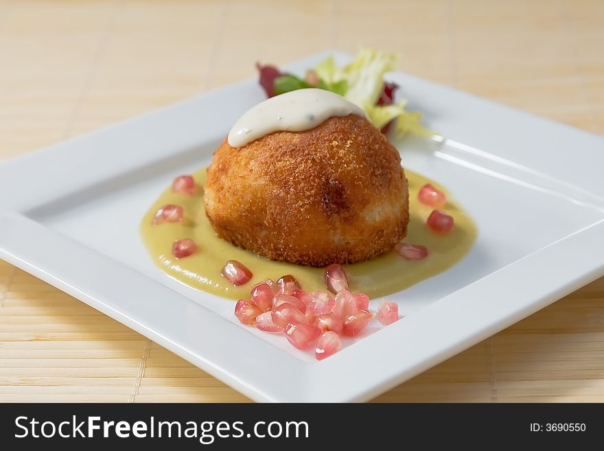 Potato pie with cream sauce and vegetables on white platter