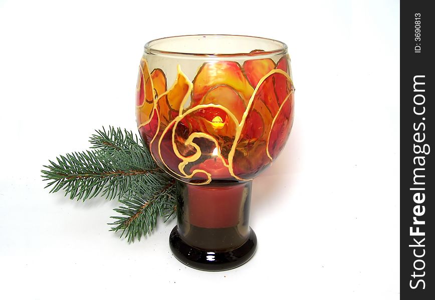 Hand-painted candlestick with burning candle and fir-tree branch as Christmas decoration