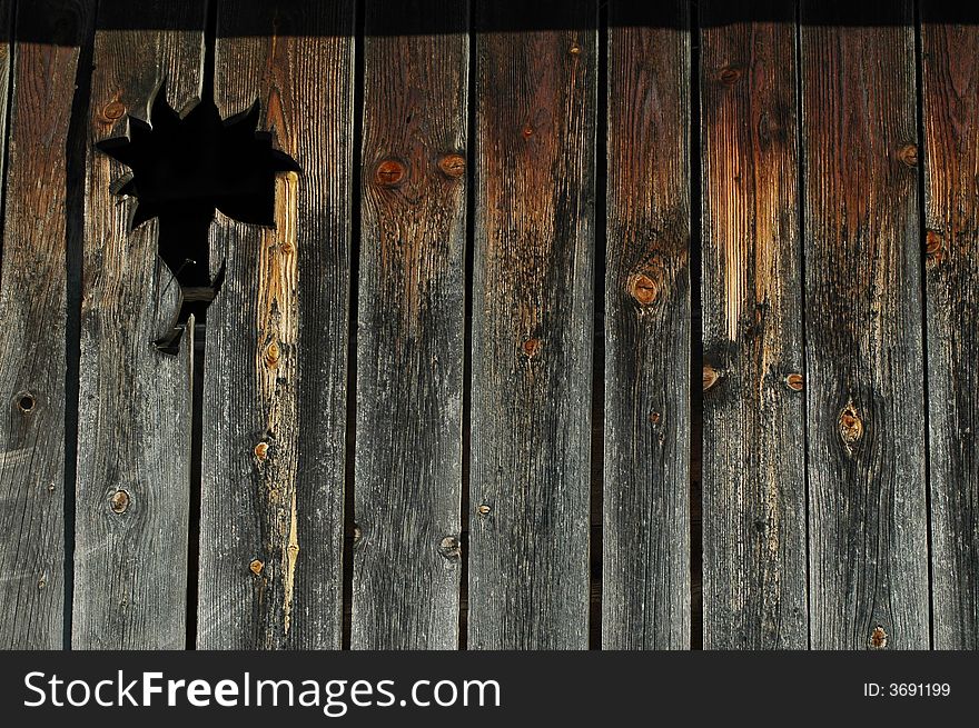 Old wooden fence with a hole in it, detail.