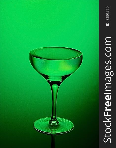 Glass for a champagne on a green background. Glass for a champagne on a green background