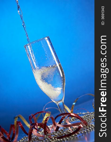 Still life with glass with champagne on the blue background