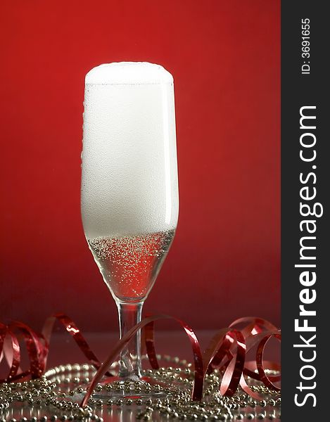 Still life with glass with champagne on the red background