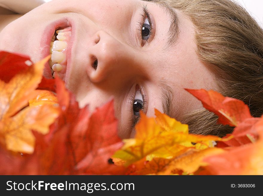 Shot of a boy Laying in autumn leaves