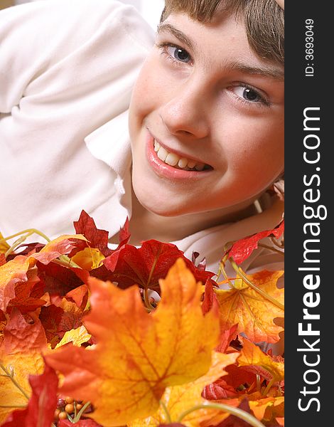 Photo of a young boy in fall leaves vertical