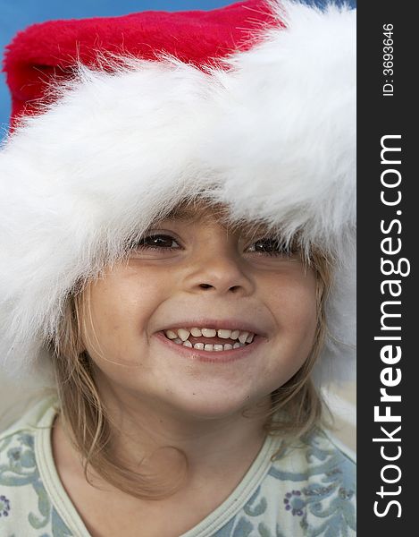 A young girl smiling in santa hat. A young girl smiling in santa hat