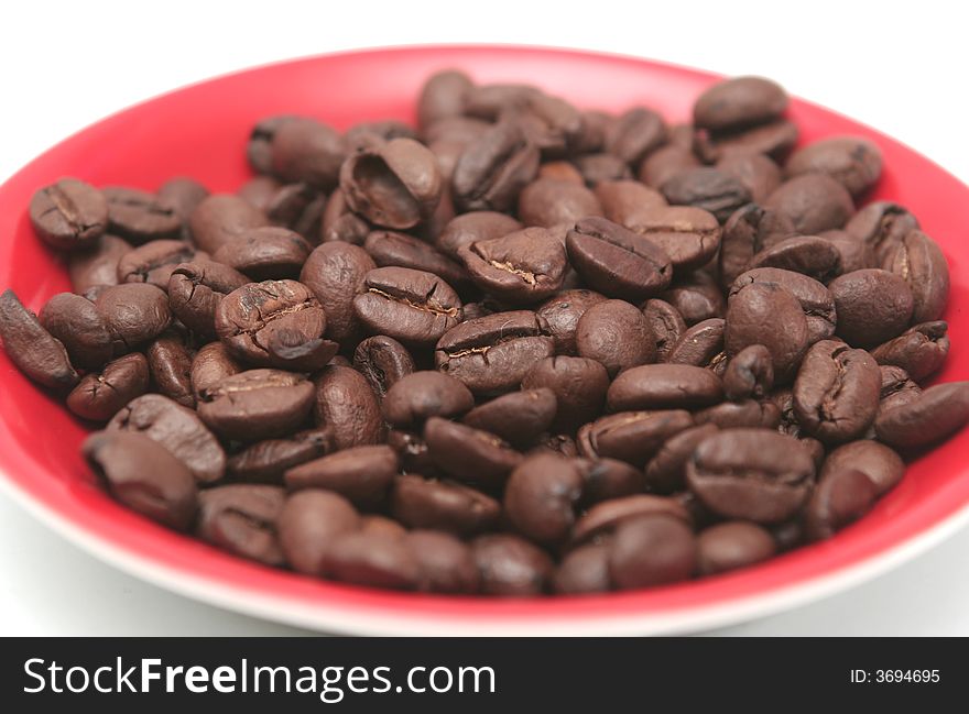 It is a lot of grains of coffee lay on a red plate