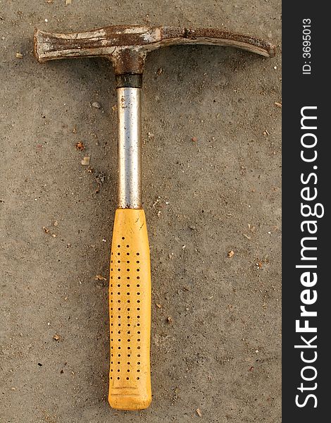 Close - up of metal hammer isolated on concrete background.