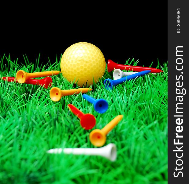 Golfball in orange tee, green fairway, isolated on black background