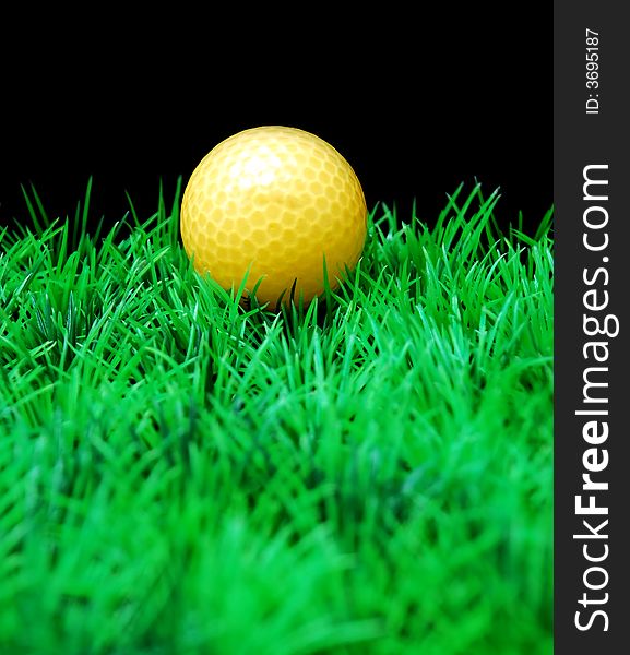 Golfball in  green fairway, isolated on black background