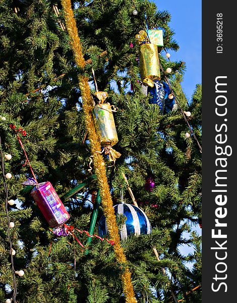 Christmas tree with toys on a background of the blue sky. Christmas tree with toys on a background of the blue sky