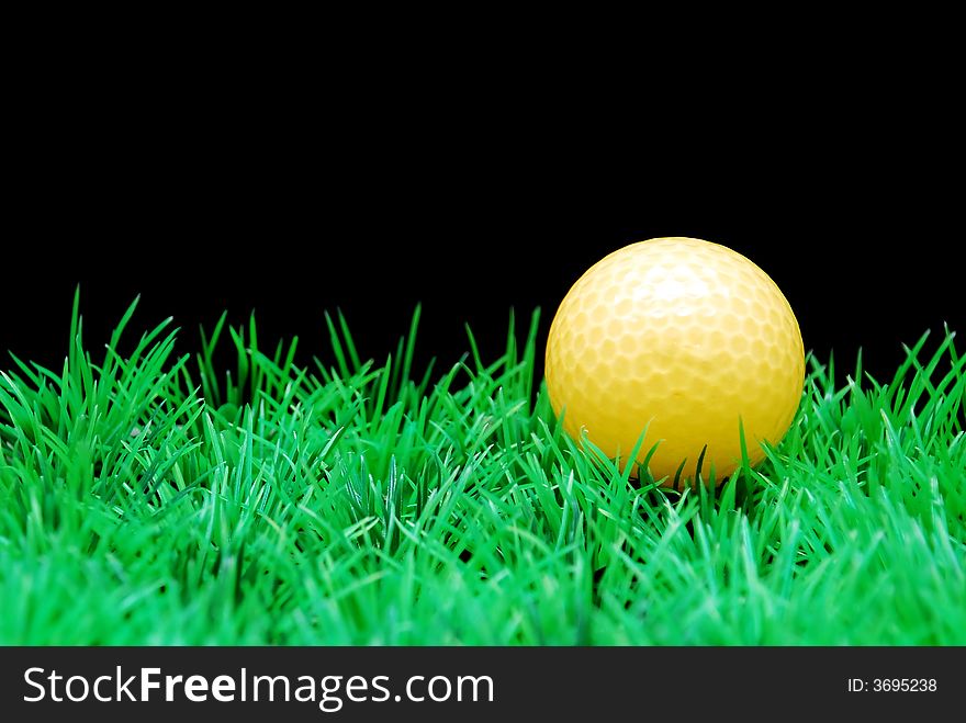 Golfball in  green fairway, isolated on black background