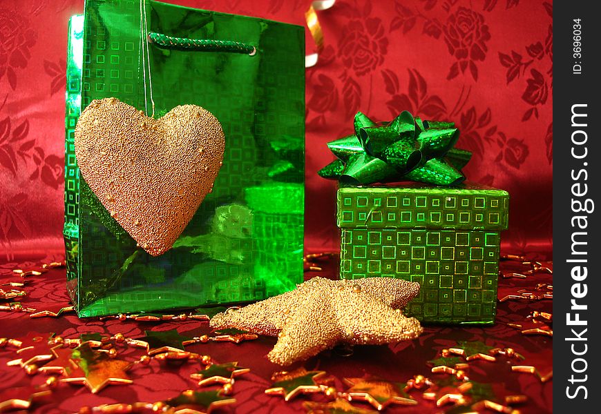 Green gift box and golden heart on celebration background