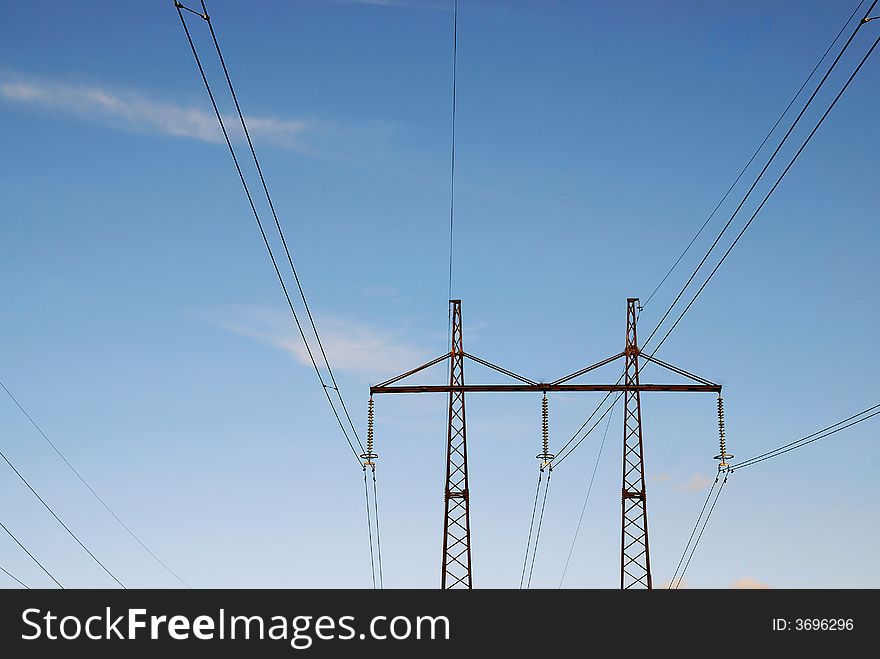 Electric line with isolators on blue sky background
