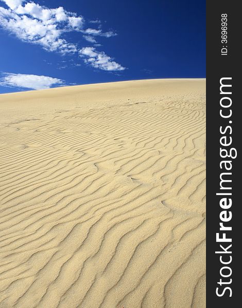 Amazing vertical view of sand dunes against deep blue sky, clear, versatile stock image. Amazing vertical view of sand dunes against deep blue sky, clear, versatile stock image