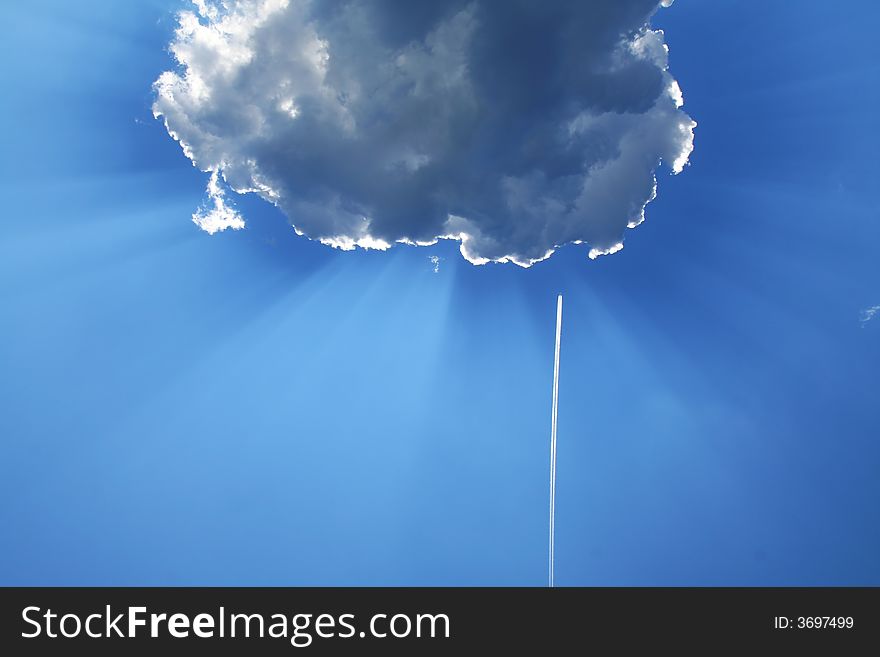 Solar beams make the way through clouds, vapor trail from an airplane. Solar beams make the way through clouds, vapor trail from an airplane