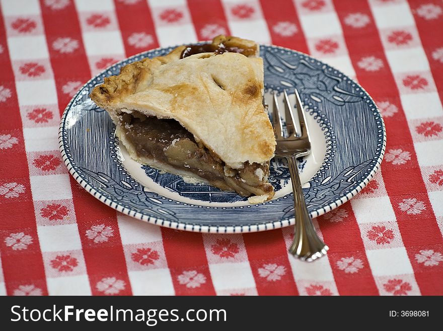 A vintage blue and white plate with slice of reak HOMEMADE apple pie.