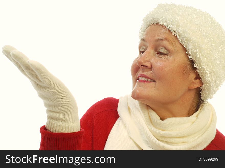 Attractive senior woman in winter fashion items looking at her hand where a gift ought to be; isolated on white. Attractive senior woman in winter fashion items looking at her hand where a gift ought to be; isolated on white