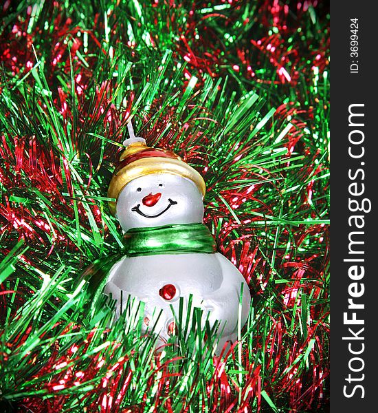 Snowman ornament with a red and green background