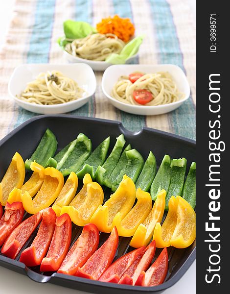 Colorful rows of green, yellow and red capsicum strips prepared for cooking on a pan. Colorful rows of green, yellow and red capsicum strips prepared for cooking on a pan