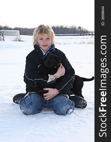 Young boy in the snow with his puppy. Young boy in the snow with his puppy