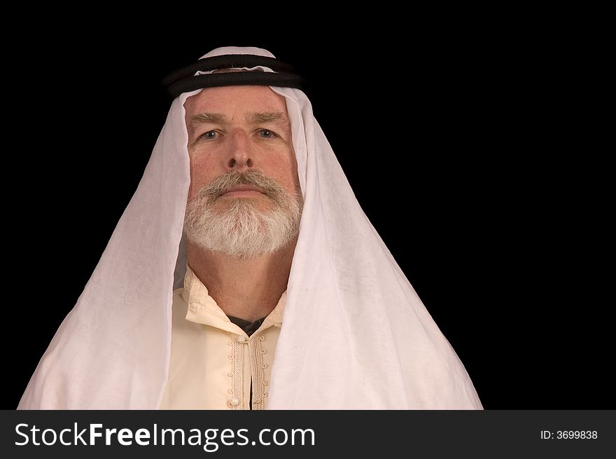 Older middle-eastern man with white beard, in Arabian headress isolated on black. Older middle-eastern man with white beard, in Arabian headress isolated on black