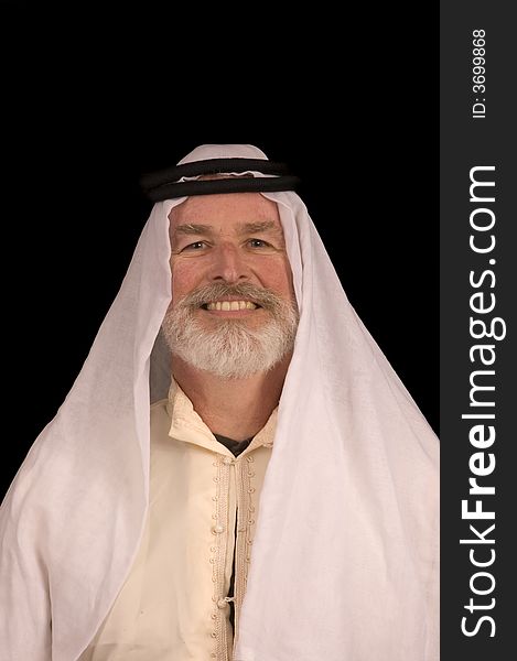 Older middle-eastern man with white beard, in Arabian headress and sunglasses isolated on black. Older middle-eastern man with white beard, in Arabian headress and sunglasses isolated on black