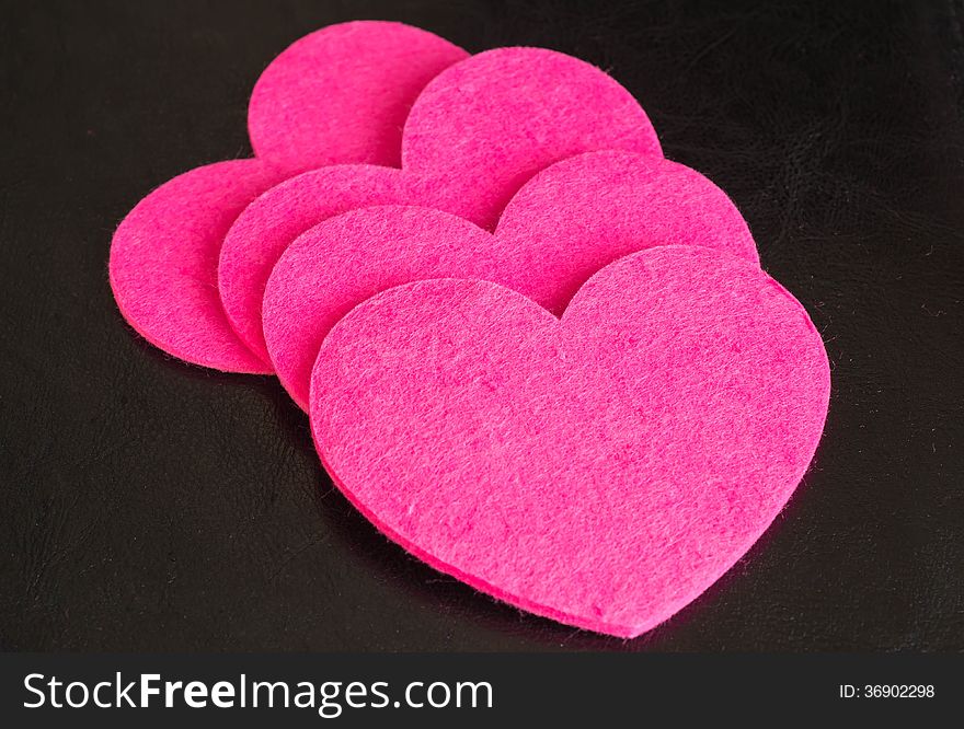 A row from four pink hearts against a dark background