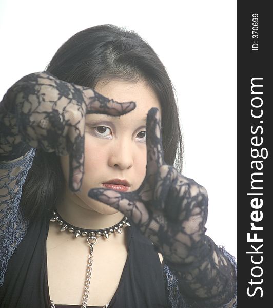 Using black laced gloved hands the woman frames her face. Using black laced gloved hands the woman frames her face