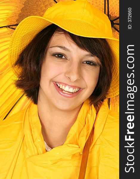 Girl smiles in her bright yellow rain gear and umbrella. Girl smiles in her bright yellow rain gear and umbrella