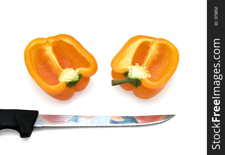 Tow half of orange bulgarian pepper over the white with knife. Tow half of orange bulgarian pepper over the white with knife