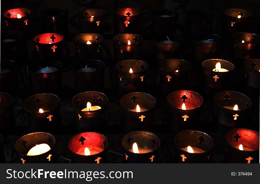 Lit prayer candles in church. Lit prayer candles in church.