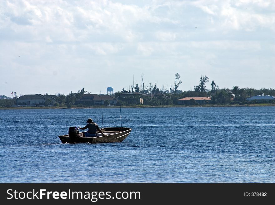 Fisherman headed out in boat on Intracoastal waterway. Fisherman headed out in boat on Intracoastal waterway