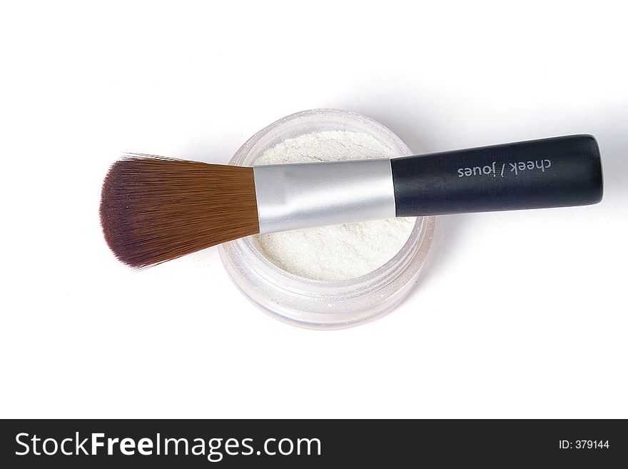 Make up brush laying over glittering powder. Make up brush laying over glittering powder