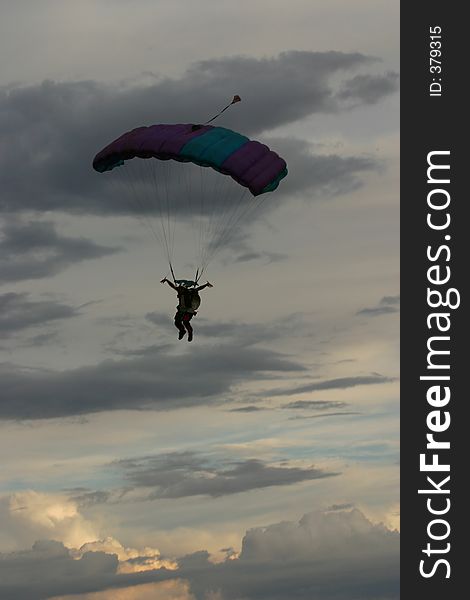 Silhouette of man ready for landing with parachute. Clouds background. Silhouette of man ready for landing with parachute. Clouds background.