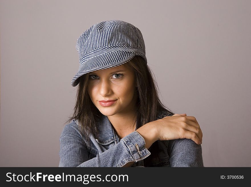 A young fresh fashion model posing with denim jacket and hat. A young fresh fashion model posing with denim jacket and hat