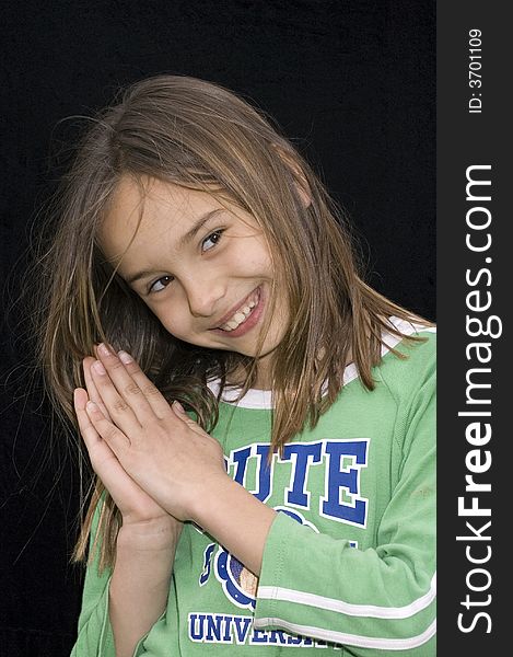 Cute caucasian american girl clasping hands together as if praying on black. Cute caucasian american girl clasping hands together as if praying on black