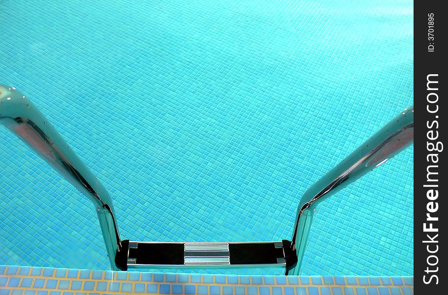 A shiny pool ladder close-up, water's surface