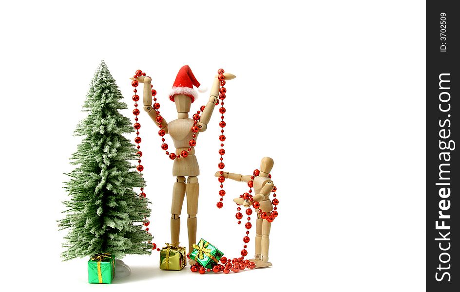 Wooden figurine adult and child decorating a christmas tree. Wooden figurine adult and child decorating a christmas tree.