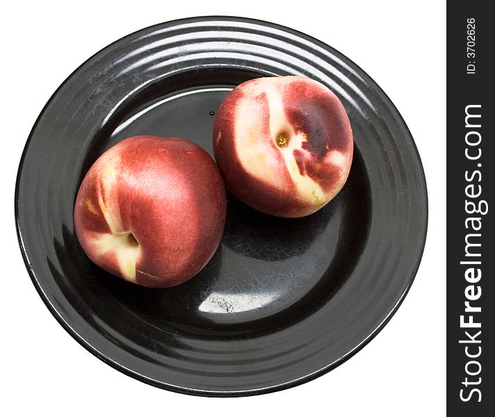 Close-up of fresh peaches on a black plate