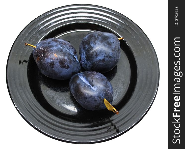 Close-up of fresh plums on a black plate