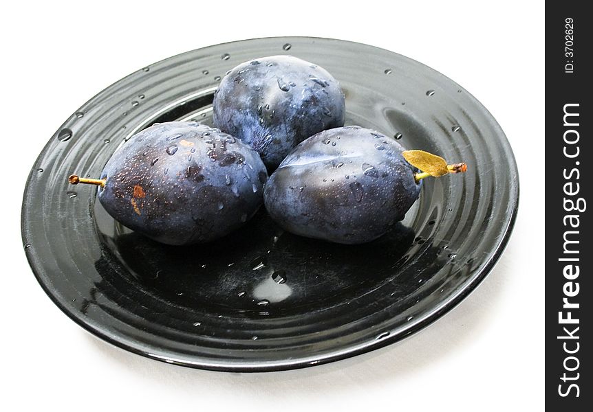 Close-up of fresh plums on a black plate