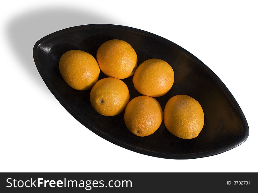 Close-up of black Japanese vase with oranges in white background in areal view. Close-up of black Japanese vase with oranges in white background in areal view