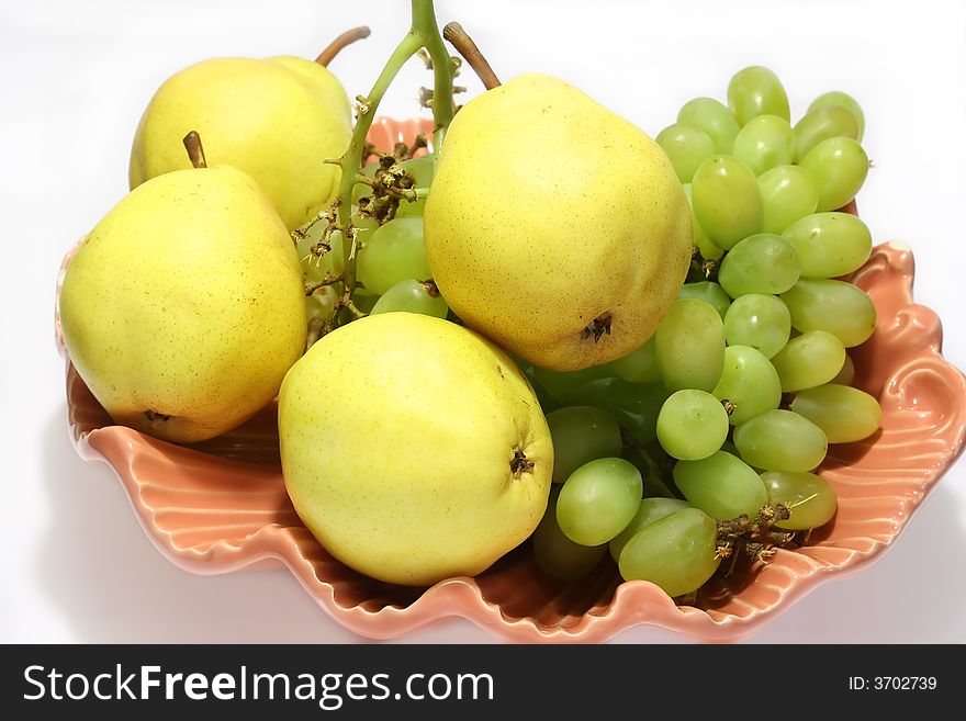 Pears and grapes in pink vase with white background