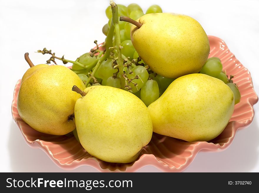 Pears and grapes in pink vase with white background