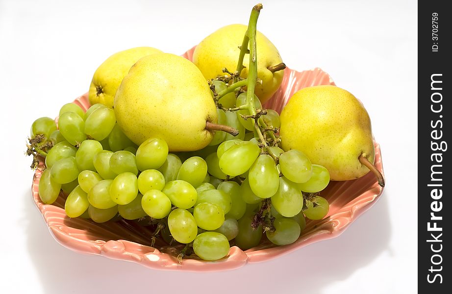 Pears and grapes in pink vase with white background