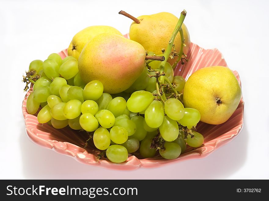 Pears and grapes in pink vase with white background