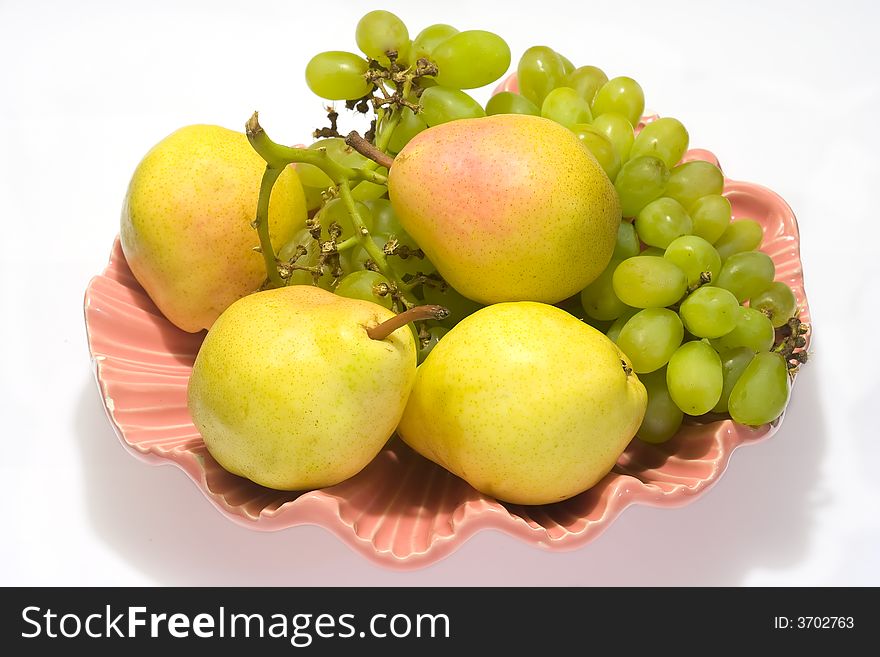 Pears and grapes in pink vase with white background