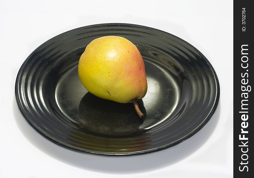 Close-up of fresh pear on a black plate