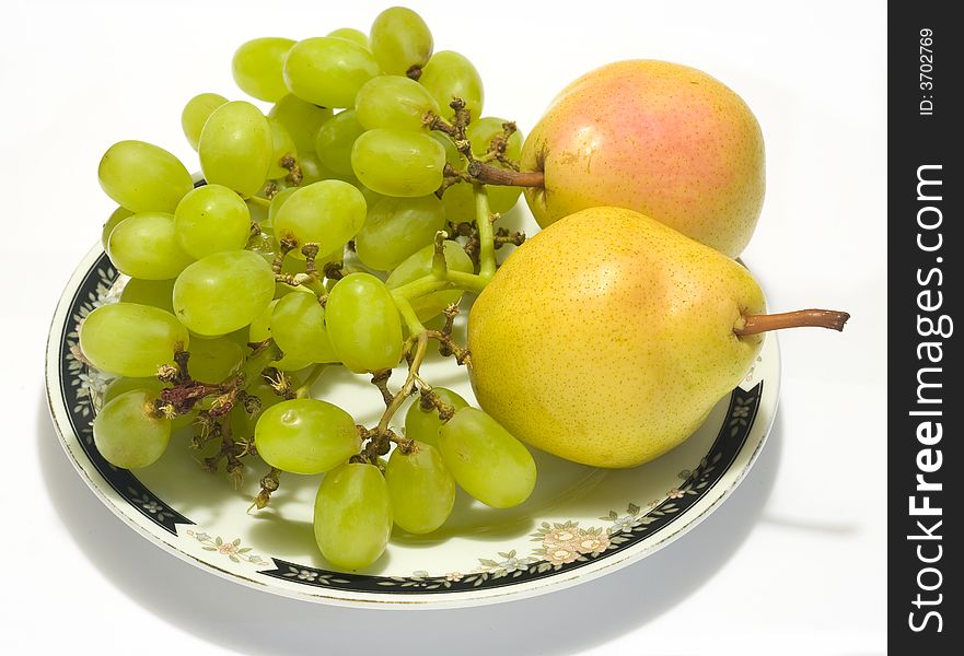 Plate with pears and grapes with shadow on white background