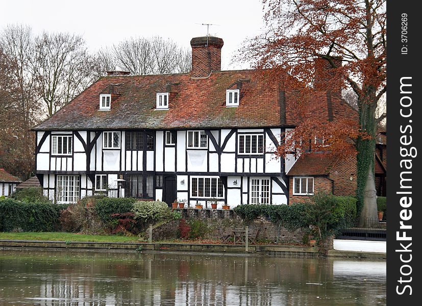 Autumn scene of a Luxury Timber Framed House on the Banks of the River Thames in England. Autumn scene of a Luxury Timber Framed House on the Banks of the River Thames in England